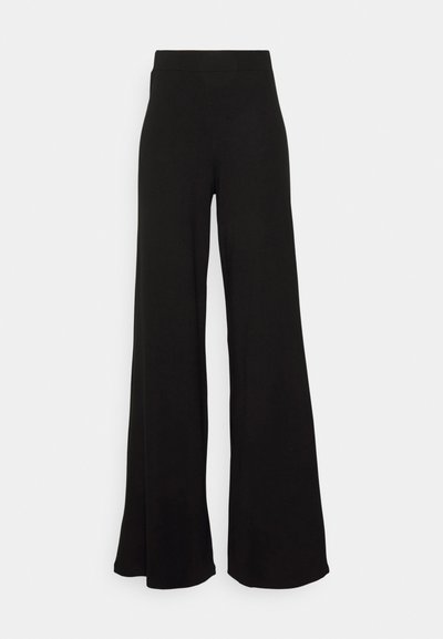 Pantalons larges noirs en matériau doux. Dotés d'une taille haute et d'un design fluide, créant une silhouette décontractée.