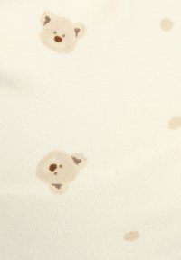 Cotton fabric featuring a cream background with a repeated pattern of light brown bear faces and small beige dots.