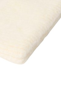 Coperta di lana di colore crema chiaro con una consistenza morbida e sottili strisce. Piana, piegata con bordi leggermente sfilacciati, che mettono in risalto calore e comfort.