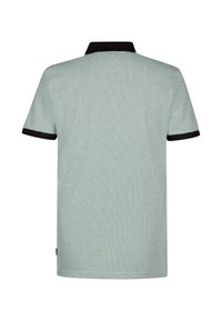 Polo vert menthe avec un motif texturé, col noir et bordures des manches, manches courtes, et un détail d'étiquette sur le côté.