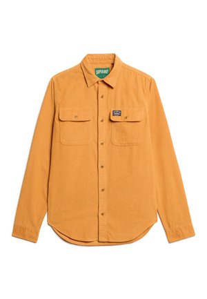 Mosterdkleurig corduroy overhemd met lange mouwen, knoopsluiting aan de voorkant en twee klepzakken op de borst, waarvan er eentje is voorzien van een klein merklabel.