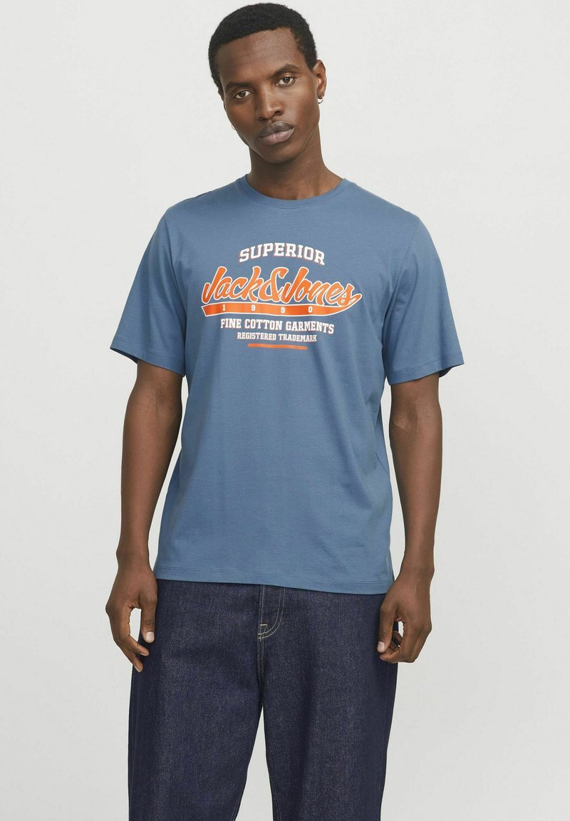 Korte mouwen blauwe katoenen t-shirt met witte en oranje grafische tekst. Losse pasvorm met een ronde hals en een casual stijl.