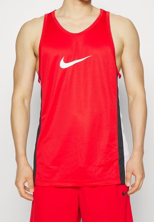 Homme portant un maillot de sport rouge sans manches avec un logo blanc Nike et un short rouge assorti avec des bandes latérales noires.