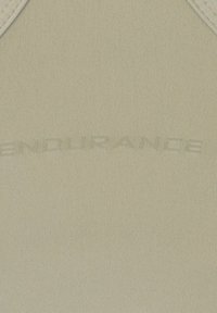 Tissu beige avec un texte en relief pâle indiquant "ENDURANCE" courbé au centre.