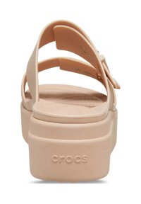 Pfirsichfarbene Crocs-Sandalen mit einem breiten Riemen hinten, einer Plattformsohle und einem strukturierten Fußbett. Verfügt über eine dekorative seitliche Akzentuierung.