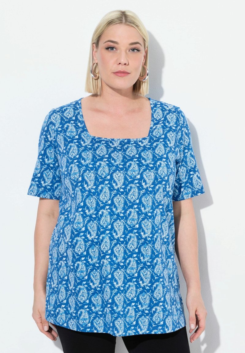 Top azul con estampado de diseño paisley en blanco, con escote cuadrado y mangas cortas. El material parece ligero y suave.