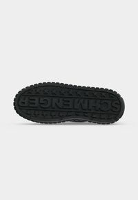 Semelle de chaussure avec une profondeur de gomme importante, motif étoile autour du périmètre et le mot « SCHMENGER » embossé au centre en grandes lettres.