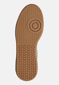 Rubber shoe sole, textured with a geometric pattern, featuring a circular detail near the center and zigzag grooves along the edges.