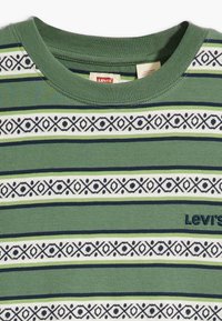 Vihreä pyöreä pääntie t-paita, jossa on vaakasuoria valkoisia, laivastonsinisiä ja vaaleanvihreitä raitoja, geometrisia kuvioita ja pieni Levi's-logo.