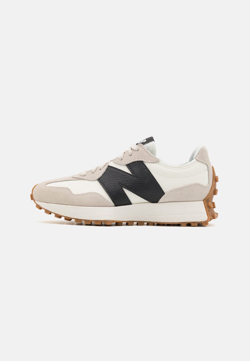 Running shoes with a white and beige suede and leather upper, featuring a large black logo, a rubber sole, and textured accents.