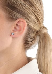 Pendientes de plata con un diseño floral, adornados con múltiples pequeñas piedras transparentes. Adecuados para un look simple y elegante.