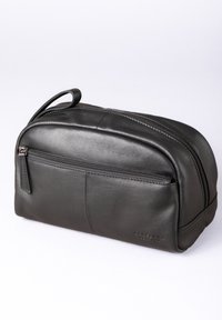 Black leather toiletry bag with a rounded shape, dual zip closure, front pocket, and a small handle for carrying. Subtle branding on the side.