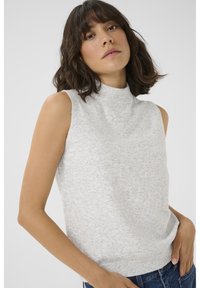 Lichtgrijze mouwloze gebreide top met een nep-halslijn en een geribbelde zoom. Zachte textuur met een licht gespikkeld patroon. Model draagt denim jeans.