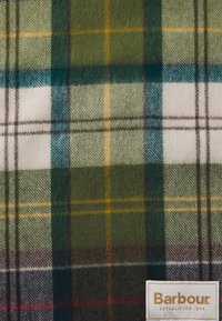 Wollen tartan stof met groene, witte en blauwe ruiten, voorzien van gele en bruine accenten. Bevat een label met de tekst "Barbour" in de hoek.