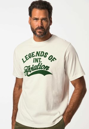 Cremfarbendes Baumwoll-T-Shirt mit grünem Text, der "LEGENDS OF INT. Aviation" lautet, mit kurzen Ärmeln und Rundhalsausschnitt.