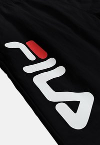 Tissu noir avec des éléments graphiques ou texte stylisé en blanc et rouge imprimés en diagonale sur la surface.