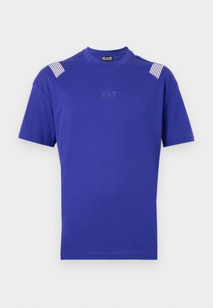 Vijolična bombažna majica s kratkimi rokavi, ki ima črtaste poudarke na ramenih in diskretno logo v središču. Gladka tekstura po celotni površini.