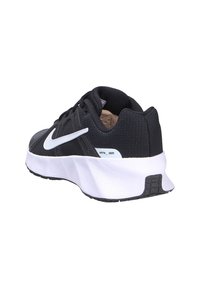 Scarpa sportiva nera con tomaia testurizzata, dettagli bianchi e soletta ammortizzata. Presenta un design classico con lacci e un dettaglio di branding.