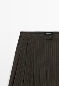 Jupe plissée en tissu gris foncé avec des rayures verticales en fil métallique. Présente une fermeture à bouton et une étiquette "Massimo Dutti" à la taille.