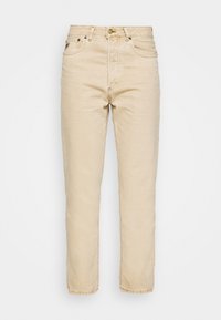Jeans de denim beige con corte recto, diseño de cinco bolsillos, cierre con botón superior y textura sutil. Presenta costuras en contraste y remaches de metal.