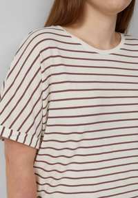 Gestreiftes T-Shirt in Creme- und Burgunderfarben, mit kurzen Ärmeln, rundem Halsausschnitt und einem weichen, strukturierten Stoff.