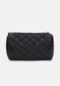 Czarna cylindryczna torba z pikowanej skóry z złotym zamkiem błyskawicznym i teksturowaną powierzchnią na białym tle.