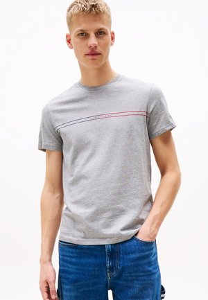 Graues Baumwoll-T-Shirt mit Rundhalsausschnitt, kurzen Ärmeln und horizontalen roten und blauen Streifen mit dem Text "TOMMY JEANS" über der Brust.
