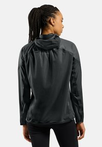 Black lightweight jacket with a hood, long sleeves, water-resistant material, featuring a smooth texture and subtle logo detail on the back.