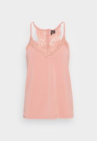 Persikofärgad linne med spetsdetaljer vid halsen, justerbara axelband och en mjuk textur. Klassisk skärning med rundad fåll.