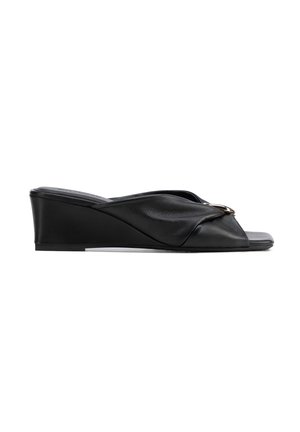 Sandale compensée noire avec une large bride dotée d'une boucle circulaire dorée, bout ouvert et talon bas.