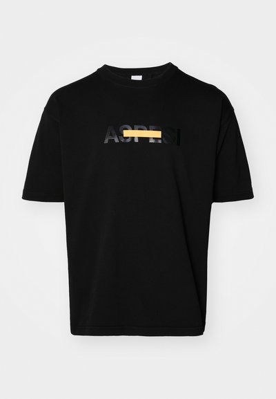 T-shirt nera a maniche corte con colletto rotondo, decorata con il testo "AS" in nero lucido e un accento orizzontale giallo.