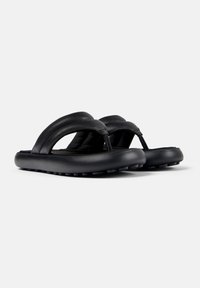 Mustat flip-flopit, jotka on valmistettu nahasta, tekstuurilla varustetulla hihnalla, litteällä kumipohjalla ja minimalistisella muotoilulla. Ominaisuutena thong-tyyli, joka tarjoaa jalkatuen.