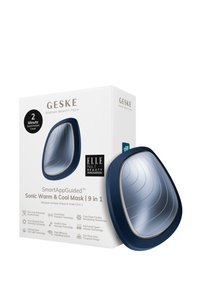 Masque Sonic Warm & Cool SmartAppGuided™, design ergonomique bleu foncé, surface argent réfléchissante, doté d'une technologie électronique pour les soins de la peau.