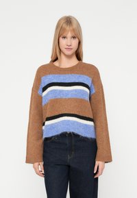 Rudas megztinis su horizontaliomis dryžuotėmis šviesiai mėlynos, tamsiai mėlynos, juodos ir baltos spalvų. Savybės: laisvas kirpimas ir trumpas dizainas.