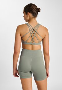 Sport-BH och shorts-set i ljusgrönt. BH:n har korslagda band bak; shortsen har en slät, åtsittande design med hög midja.