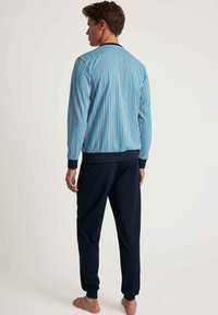 Herren Pyjama-Set bestehend aus einem blau gestreiften Oberteil mit gerippten Bündchen und einer marineblauen Hose. Das Oberteil weist vertikale Streifen in Blau, Orange und Weiß auf.