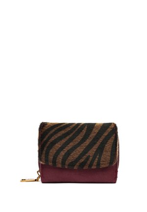 Cartera compacta con solapa con patrón de cebra en marrón y negro y cuerpo de cuero rojo oscuro, con un pequeño tirador de cremallera dorado en el lateral.