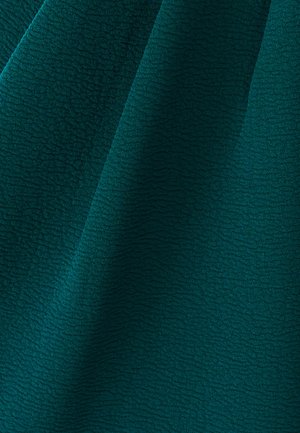 Sügava türkiissinise tooniga tekstuuriga kangas, millel on peen lainekuju ja pehme viimistlus, mis langeb elegantselt.