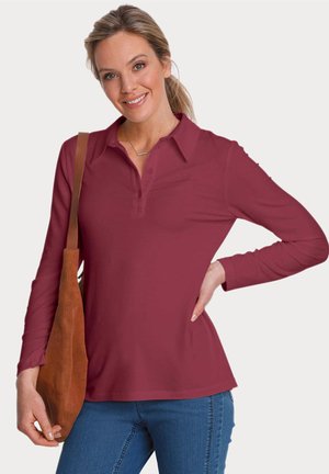 Polo a maniche lunghe color bordeaux, con colletto, patta dei bottoni e vestibilità comoda. Abbinato a una borsa marrone e jeans di denim.