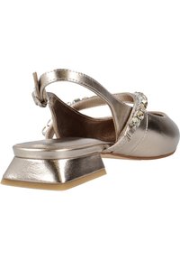 Zapato slingback dorado metálico con un tacón cuadrado bajo, adornado con brillantes claros en la tira, textura suave y punta redonda.