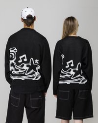 Svarte gensere med et teksturert hvitt grafisk design som har musikalske notater og stjerner, kombinert med svarte shorts, vist fra baksiden.