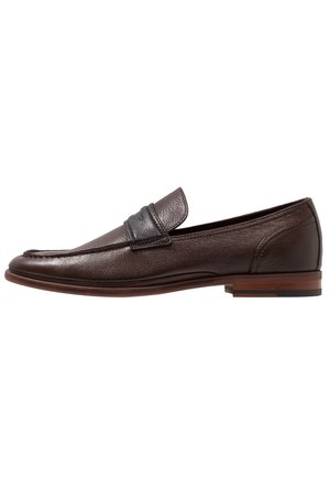 Mocassino da uomo in pelle marrone scuro con tacco basso e dettaglio di fascia in pelle nera sulla parte superiore, vista laterale su sfondo bianco.