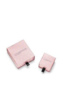 Boîtes-cadeaux en carton rose, une grande avec des pois en feuille d'or et un logo, une petite avec un design similaire, chacune avec une languette de tirage en ruban noir.