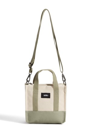 Petit sac fourre-tout bicolore beige et olive en toile avec poignées courtes, bandoulière longue réglable et écusson logo Vans à l’avant.