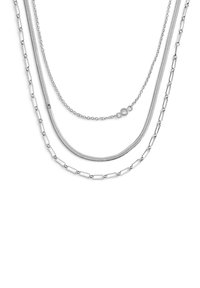 Trois chaînes de ton argenté aux designs variés : une chaîne serpent lisse, une chaîne boîte texturée, et une chaîne à maillons avec des accents circulaires.