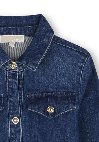 Veste en denim bleu foncé avec col pointu, devant boutonné et poche poitrine boutonnée sur le côté droit.