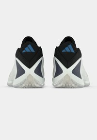 Melnbaltas sporta kurpes ar teksturētu augšdaļu, izceļamu papēža dizainu, gumijas zolīti ar rakstainu saķeri un zilām detaļām.