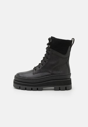 Black ankle boots, made of leather and suede. Features a padded collar, lace-up front, and thick rubber sole with a tread pattern.