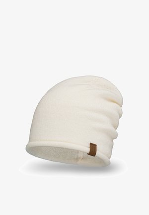 Cream-colored beanie with a soft knit texture, featuring a folded cuff and a small leather tag on the side. Smooth, rounded shape.