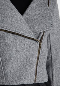 Gray wool-blend jacket with a fitted design, diagonal zipper, and snap closure. Features a soft texture and tailored lapels.